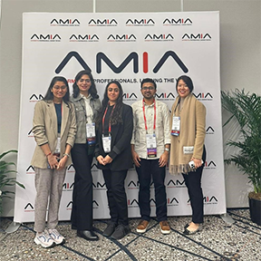 Students standing in front of AMIA sign